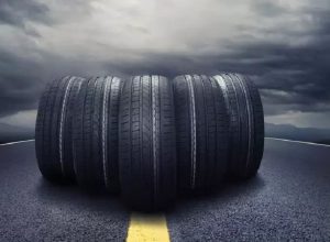 Image of Car tires close-up wheel placed on the road on dusky cloud background.